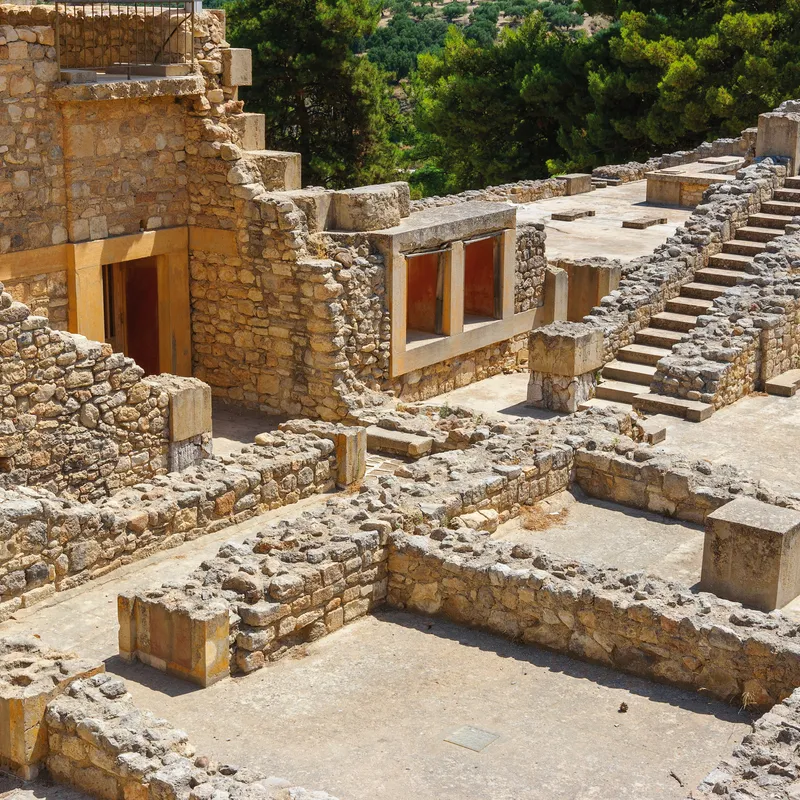 Ruinen des Palasts von Knossos auf Kreta, mit alten Steinmauern und Treppen.