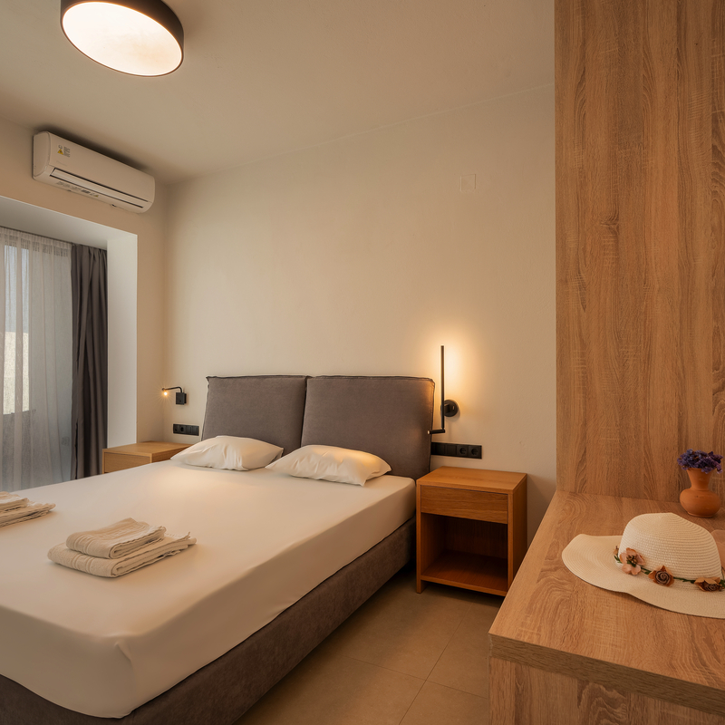 Modernes Hotelzimmer mit Doppelbett und Balkonaussicht.