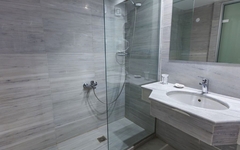 Modernes Badezimmer mit Dusche, Waschbecken und Spiegel.