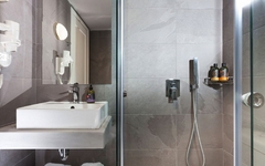Modernes Badezimmer mit Dusche, Waschbecken und Ablage im Giannoulis Santa Marina Beach Hotel.