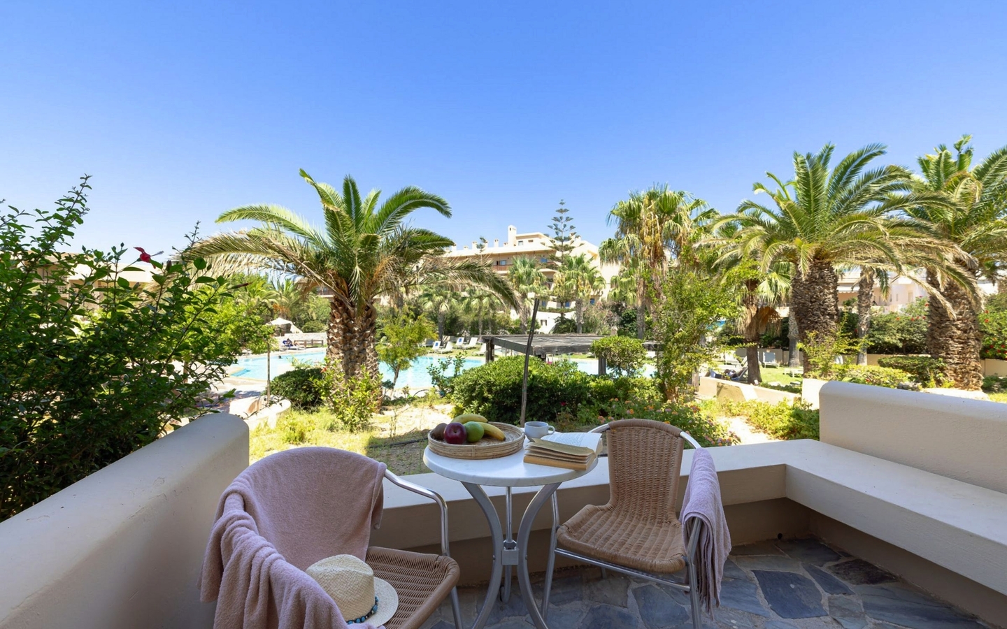 Terrasse mit Sitzmöbeln und Blick auf Garten mit Palmen