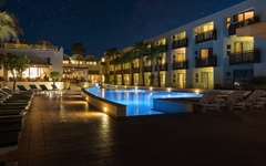 Außenansicht des Giannoulis Santa Marina Plaza bei Nacht mit beleuchtetem Pool.