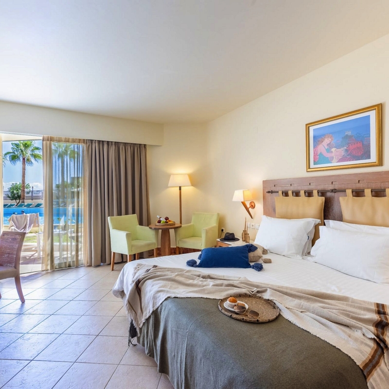 Doppelzimmer mit Balkon und Blick auf den Pool in einem Hotel auf Kreta.