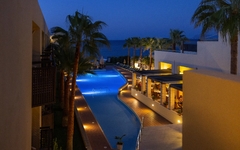 Hotelpool bei Nacht mit Meerblick und Palmen in Kreta.