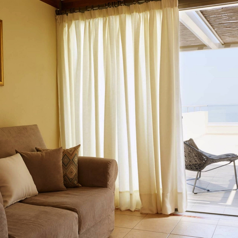 Juniorsuite mit Sofa, Blick auf Terrasse und Meer.