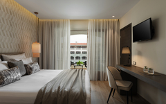 Zimmer mit Doppelbett, modernem Dekor und Blick auf den Pool.