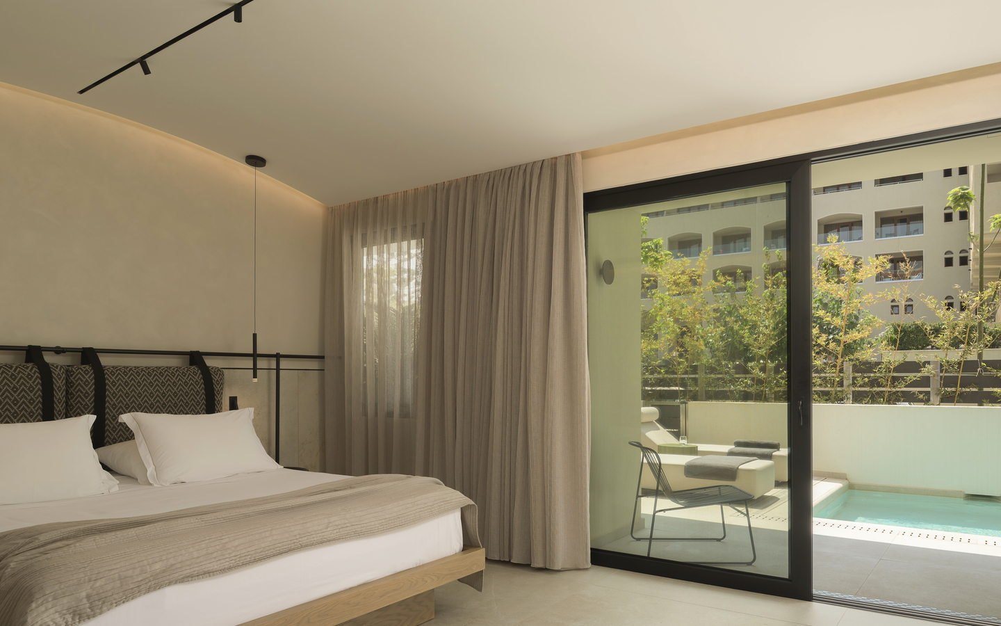 Hotelzimmer mit Doppelbett, Balkon und Blick auf einen privaten Pool.