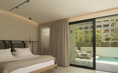 Hotelzimmer mit Doppelbett, Balkon und Blick auf einen privaten Pool.