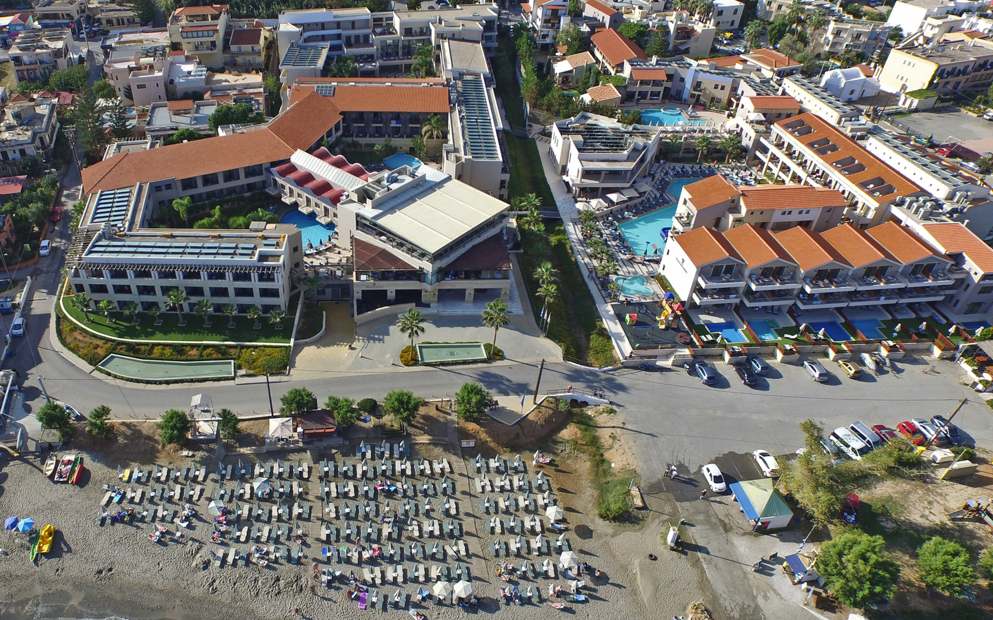 Luftaufnahme des Porto Platanias Beach Resort auf Kreta mit Strand und Liegestühlen