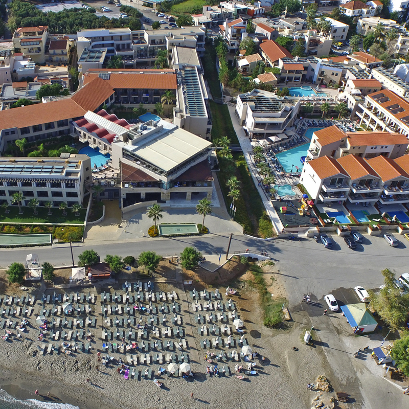 Luftaufnahme des Porto Platanias Beach Resort auf Kreta mit Strand und Liegestühlen