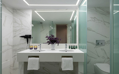 Moderner Badezimmerbereich mit Marmordekor und Doppelwaschbecken im Hotel.