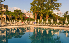 Pool mit Liegestühlen und Palmen bei Hotel in Kreta, Griechenland.