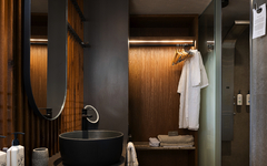 Modernes Hotelbadezimmer mit Waschbecken, Spiegel und Kleiderständer