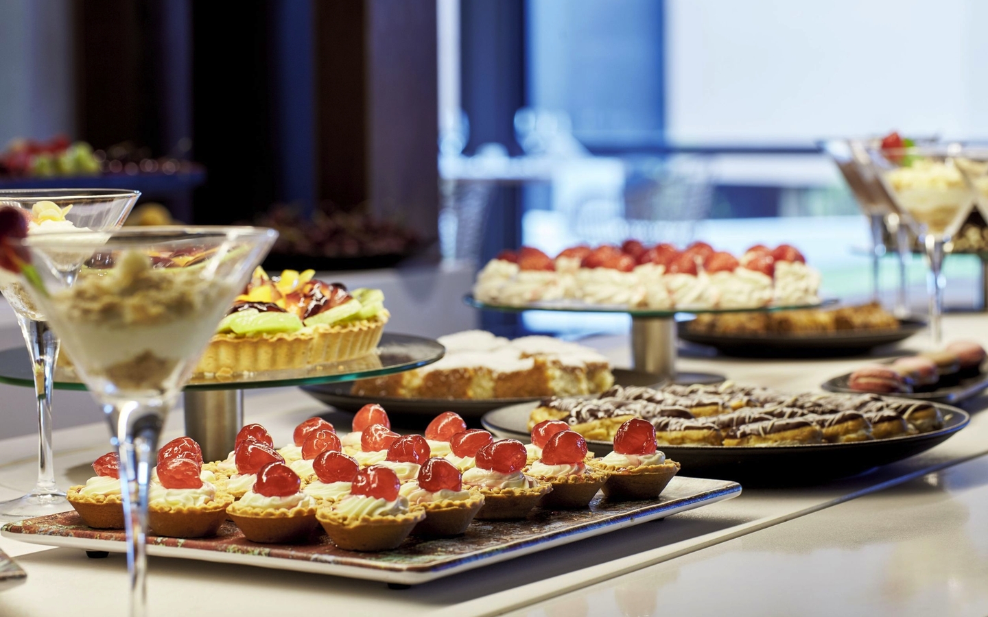 Dessertbuffet mit verschiedenen Kuchen und Süßspeisen in einem Hotelrestaurant.