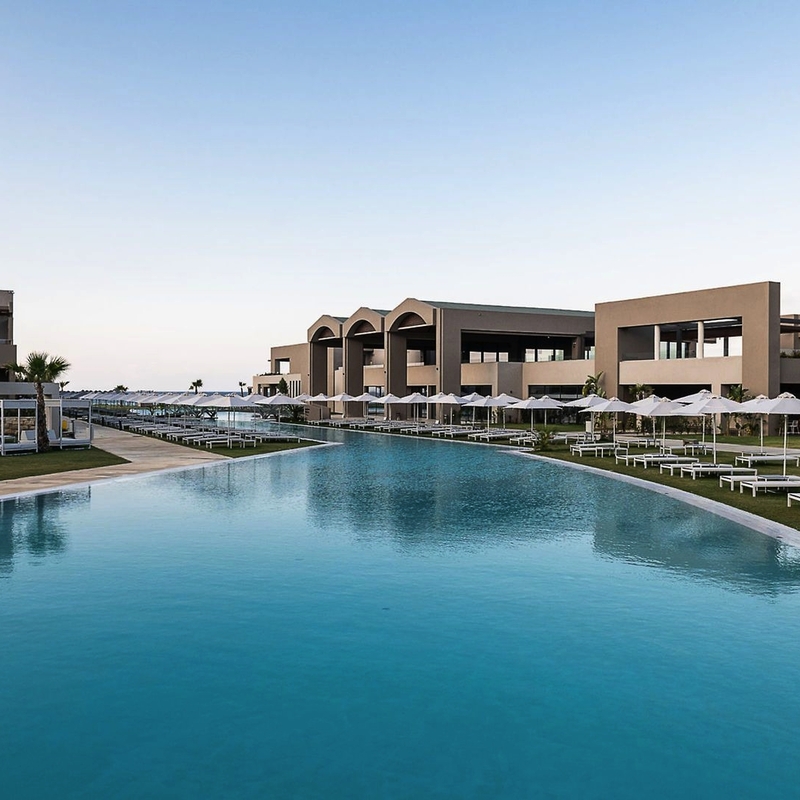 Außenansicht des Euphoria Resorts auf Kreta, mit großem Pool und Gebäuden im Hintergrund.