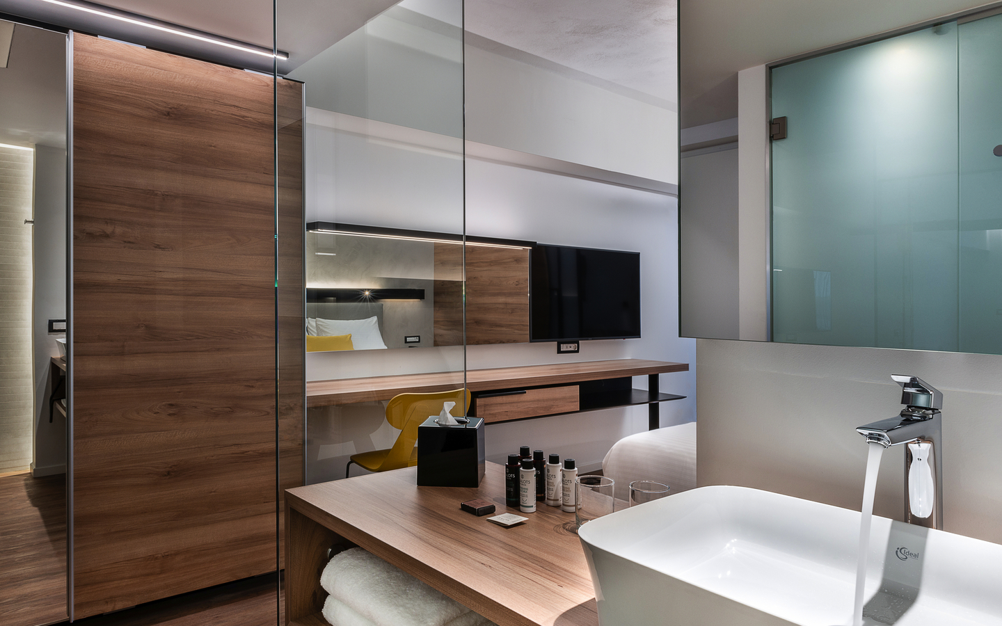 Moderne Hotel-Suite mit elegantem Badezimmer, Holzelementen und Blick auf Outdoor-Bereich.