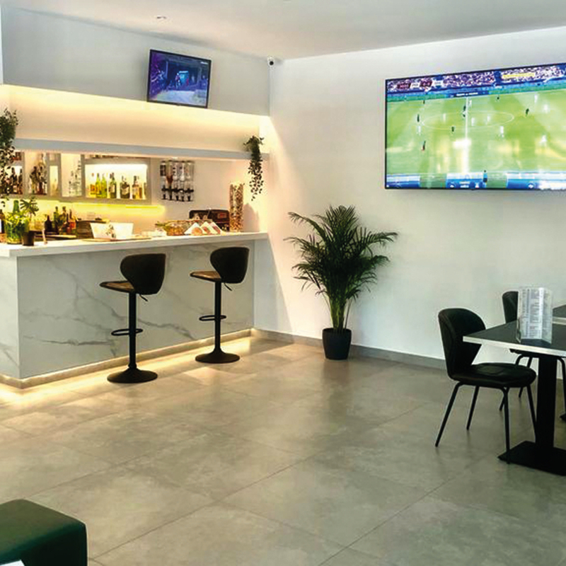 Barbereich eines modernen Hotels mit Sitzgelegenheiten und Fernsehern an der Wand.