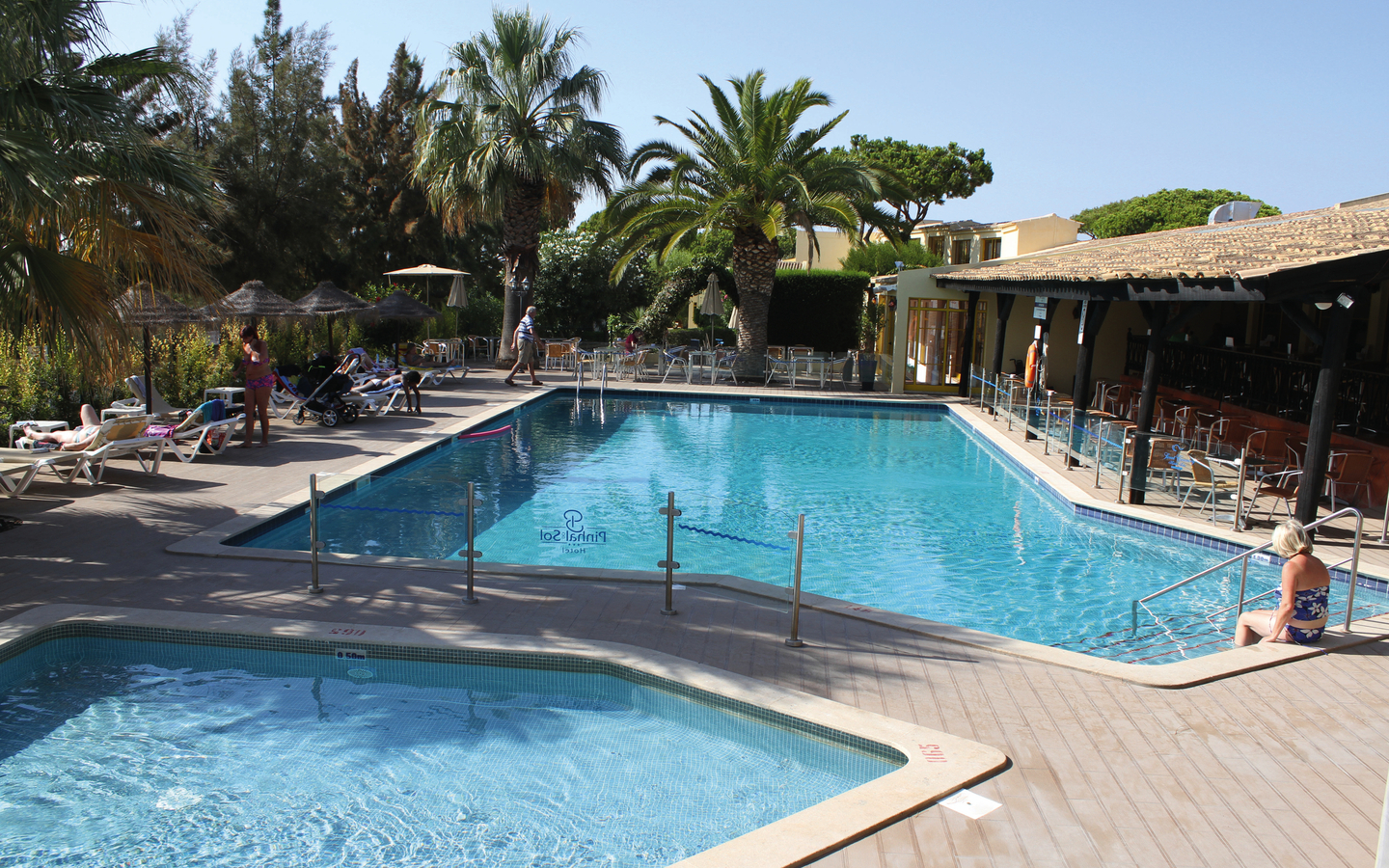 Hotelpool mit Liegen und Palmen im Hotel Pinhal do Sol, Algarve, Portugal.