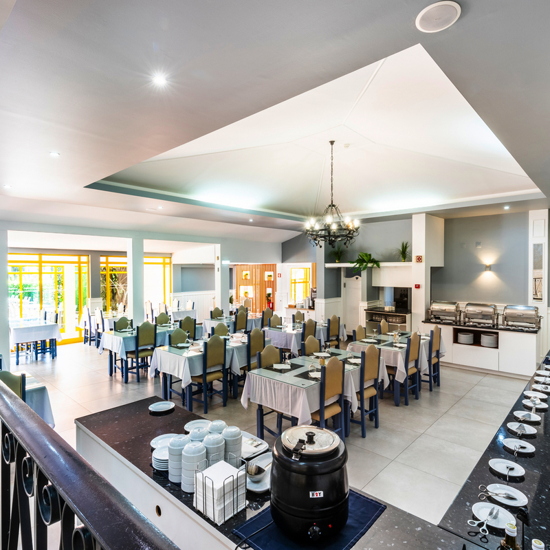 Heller Speisesaal mit gedeckten Tischen und Buffet im Hotel Pinhal do Sol.