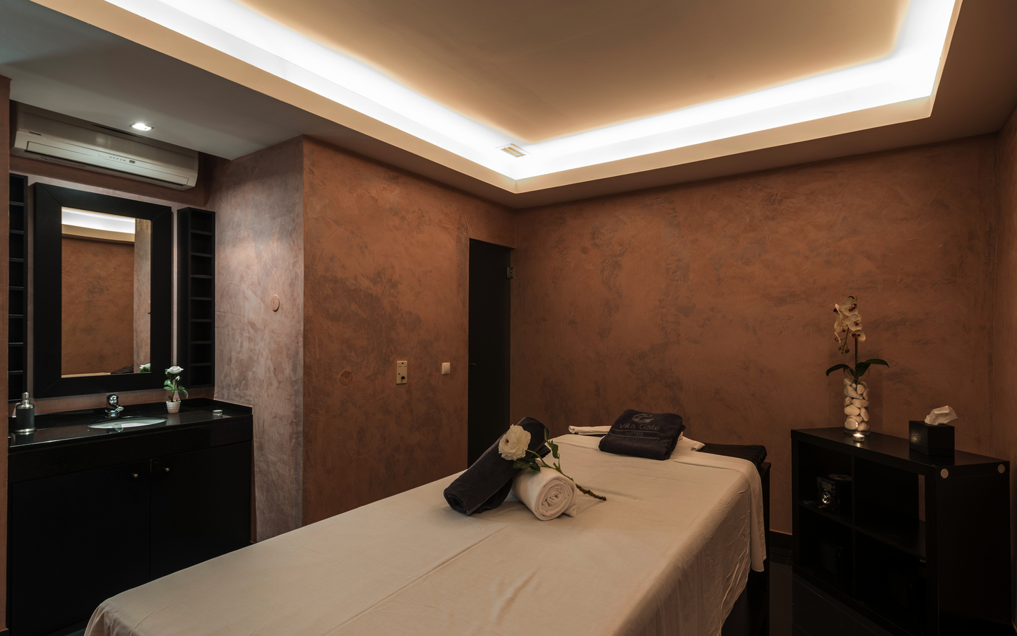 Massageraum im Hotel Vila Galé Atlântico, Algarve, mit Liege und Handtüchern.