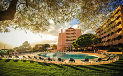 Hotel Vila Galé Atlântico mit Pool und Gartenanlage bei Sonnenuntergang, Algarve, Portugal.