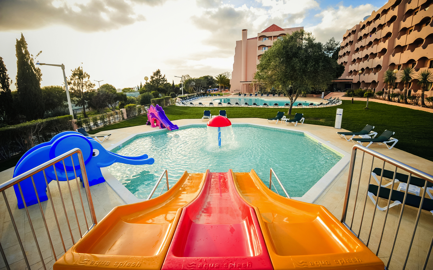 Poolbereich des Hotel Vila Galé Atlântico mit Rutschen und Liegestühlen.