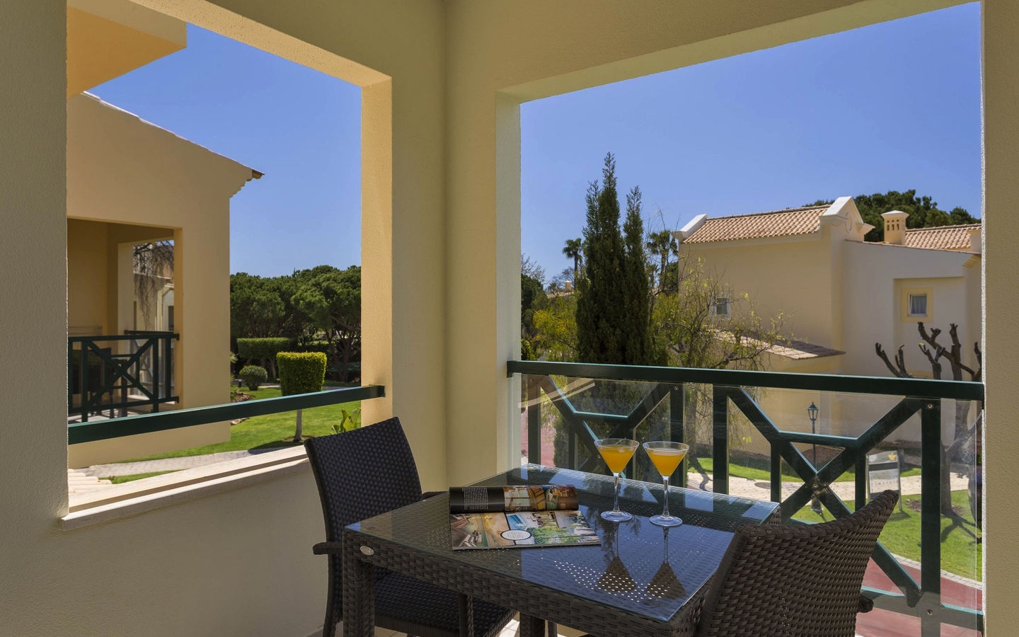 Balkon im Adriana Beach Club Resort mit Tisch, Stühlen und Ausblick auf Gartenanlagen.