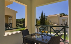 Balkon im Adriana Beach Club Resort mit Tisch, Stühlen und Ausblick auf Gartenanlagen.