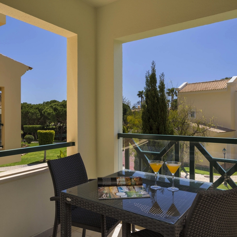 Balkon im Adriana Beach Club Resort mit Tisch, Stühlen und Ausblick auf Gartenanlagen.