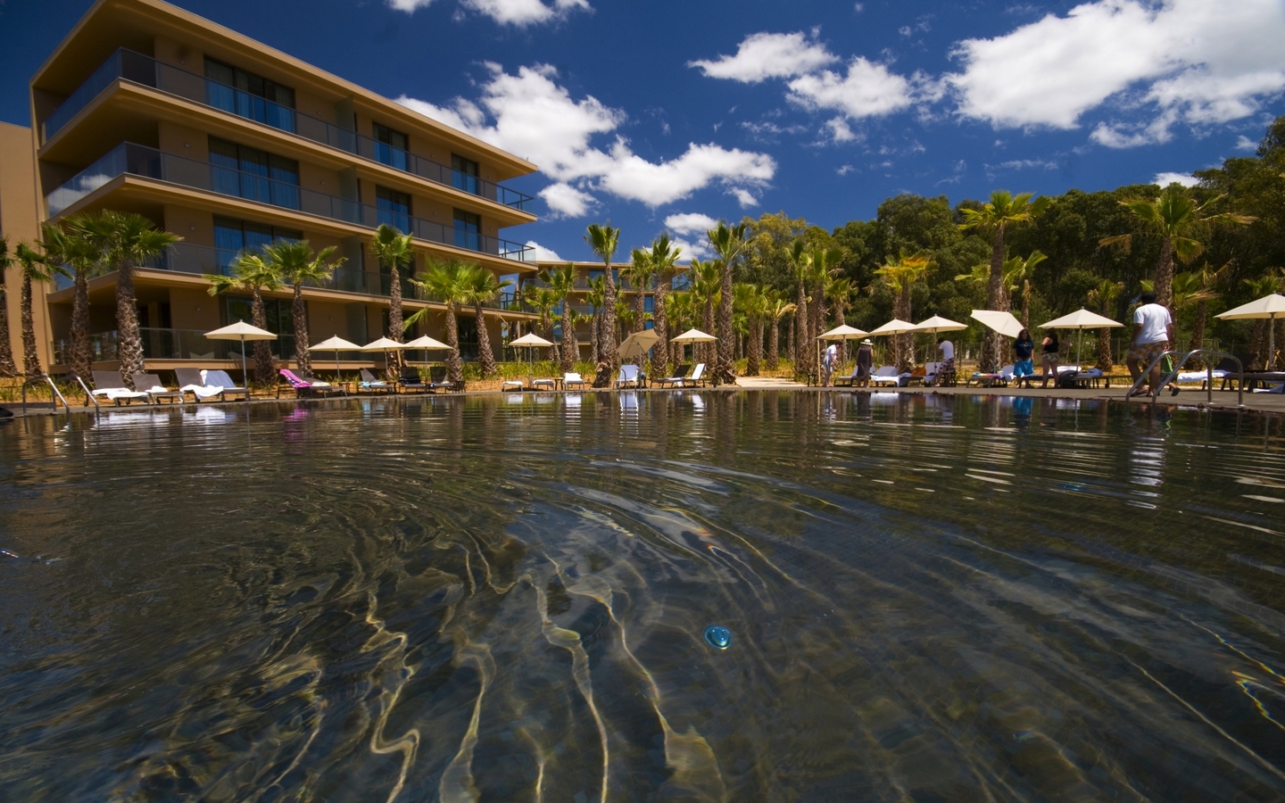 Hotel mit Pool und Palmen im Resort Salgados, Algarve, Portugal.