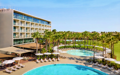 Hotel mit Palmengarten, Pool und Sonnenschirmen in Algarve, Portugal.