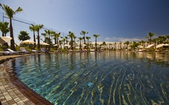 Außenpool mit Palmen und Liegestühlen im Marriott Salgados Golf Resort, Algarve.
