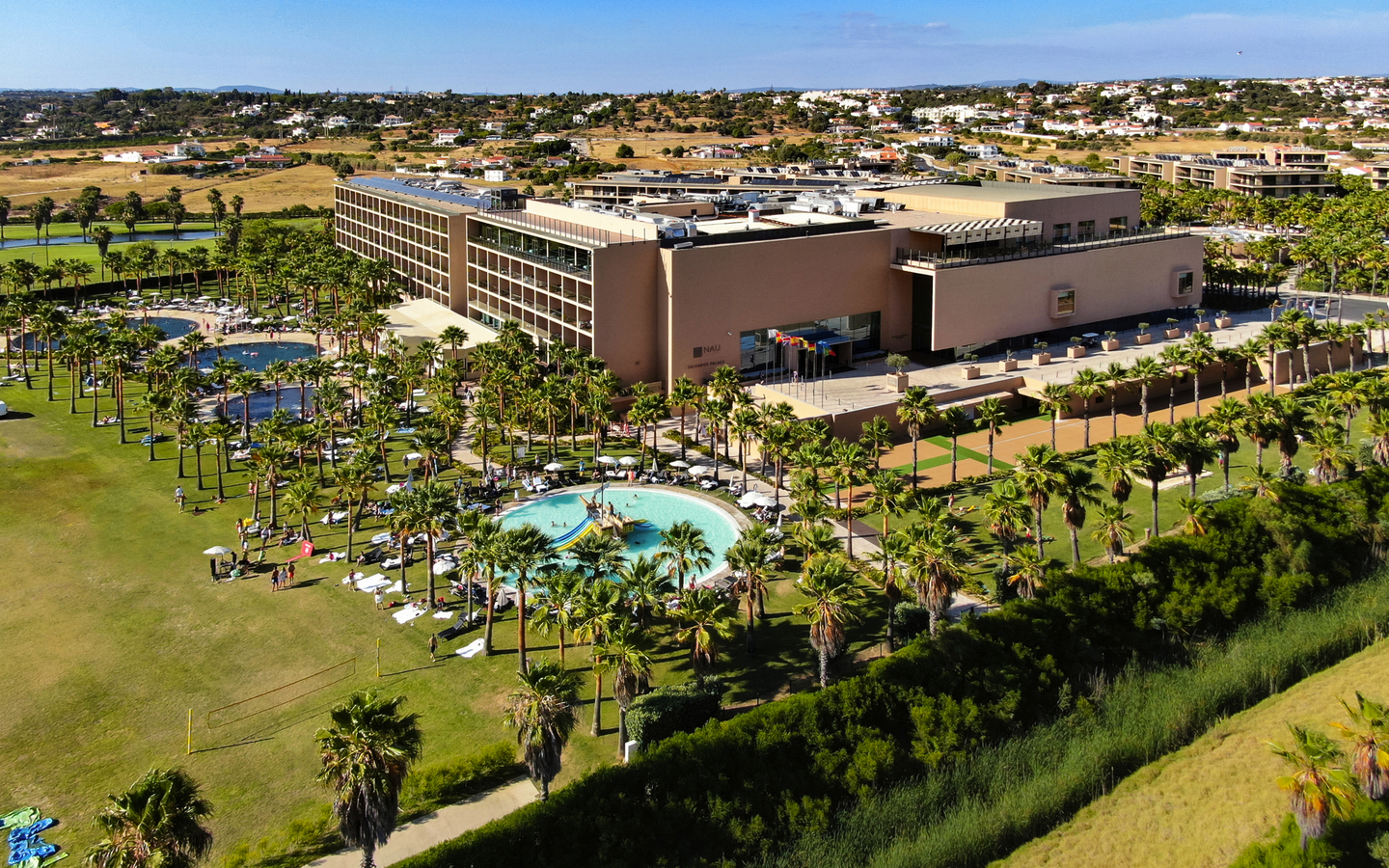 Hotel mit Palmen und Pools in Algarve, Portugal, aus der Luftperspektive.
