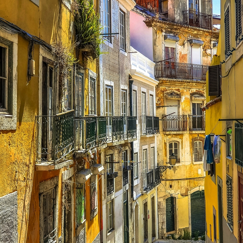 Bunte Häuser in einer schmalen Straße der Altstadt von Lissabon, Portugal.