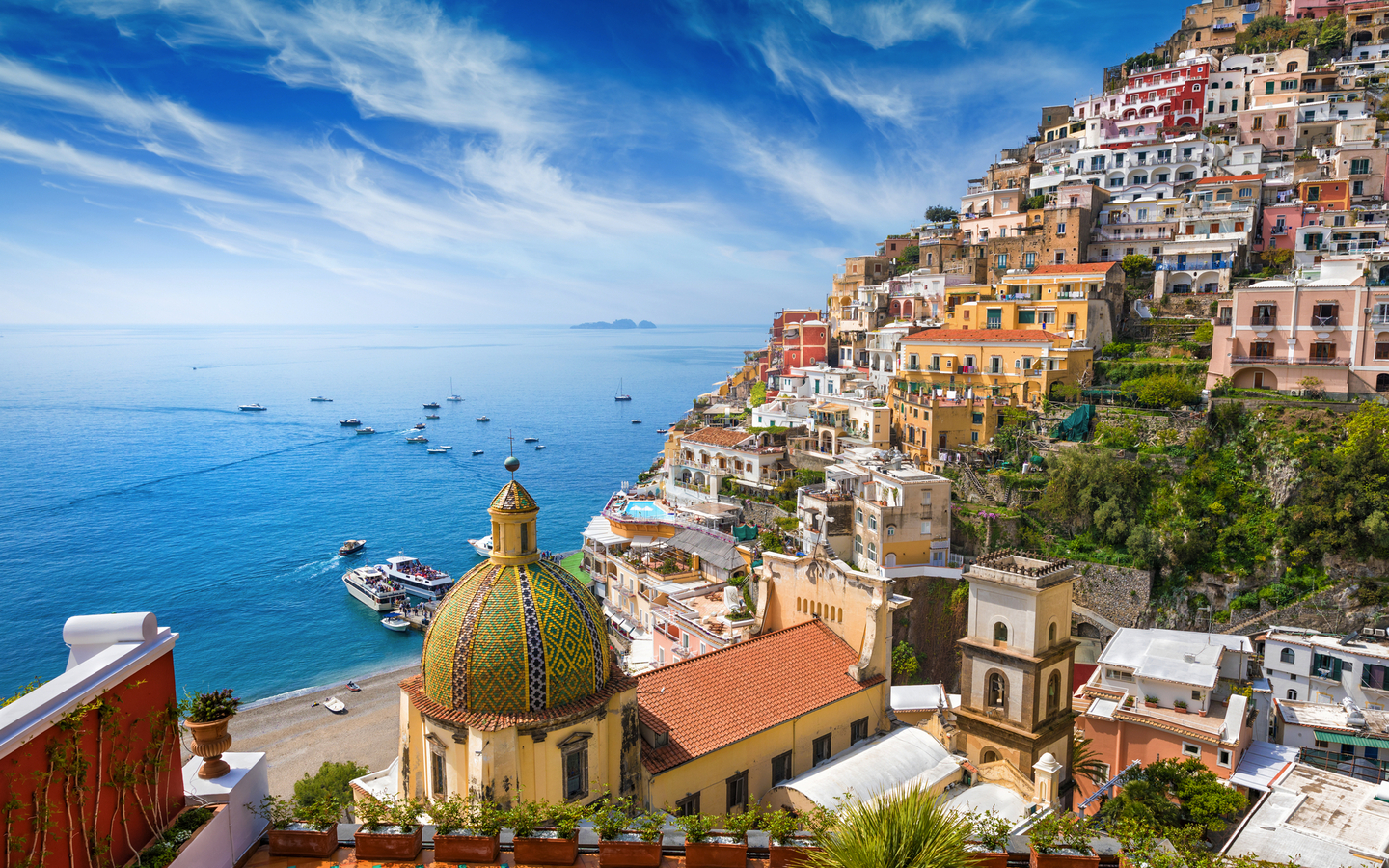 Küstenstadt Positano in Italien mit bunten Gebäuden und blauer Küste.