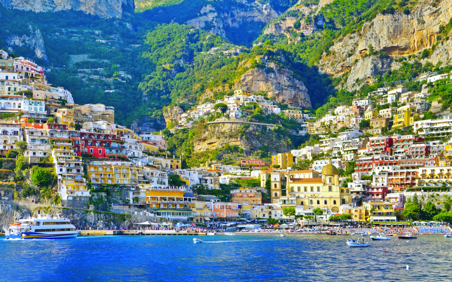 Bunte Häuser an einer steilen Küste oberhalb des Meeres.