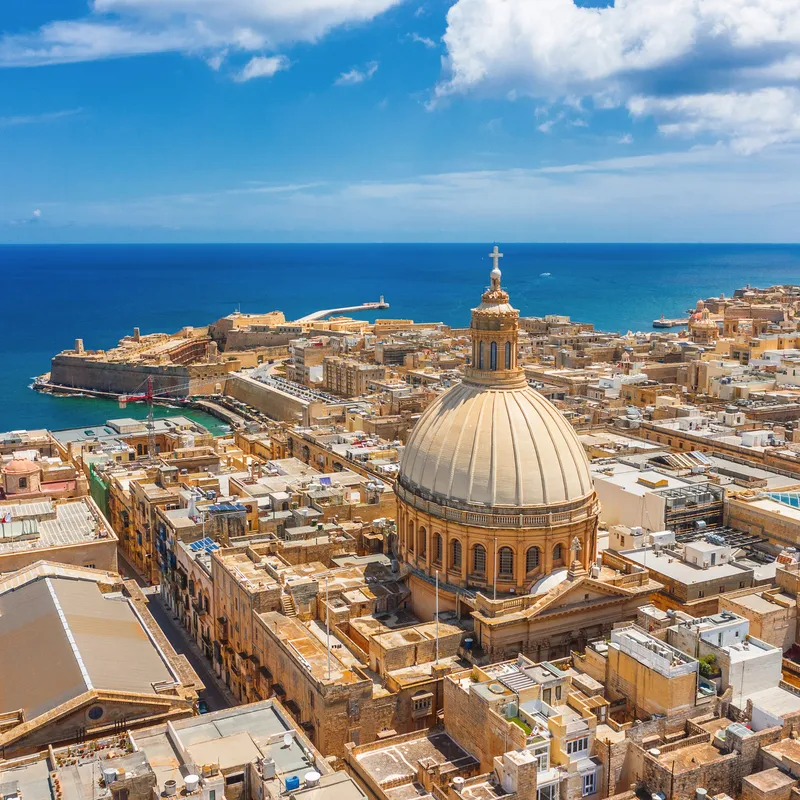 Stadtansicht von Valletta, Malta mit der Kuppel der Karmelitengemeinde und Meer im Hintergrund.