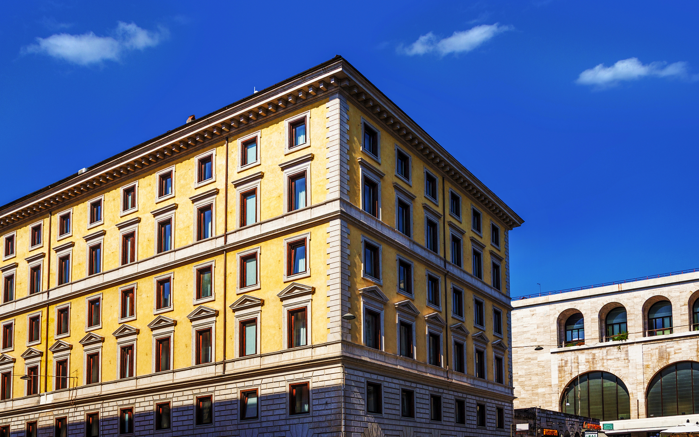 Fassade eines mehrstöckigen Hotels in Rom bei klarem Himmel.