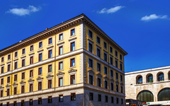 Fassade eines mehrstöckigen Hotels in Rom bei klarem Himmel.
