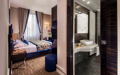 Modernes Hotelzimmer mit Doppelbett und angrenzendem Badezimmer in Rom