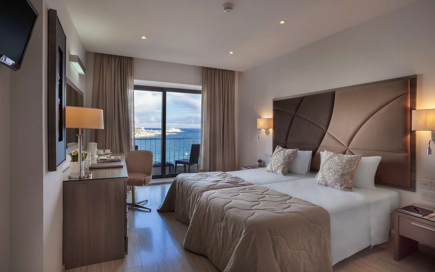 Hotelzimmer mit Doppelbett und Blick aufs Meer