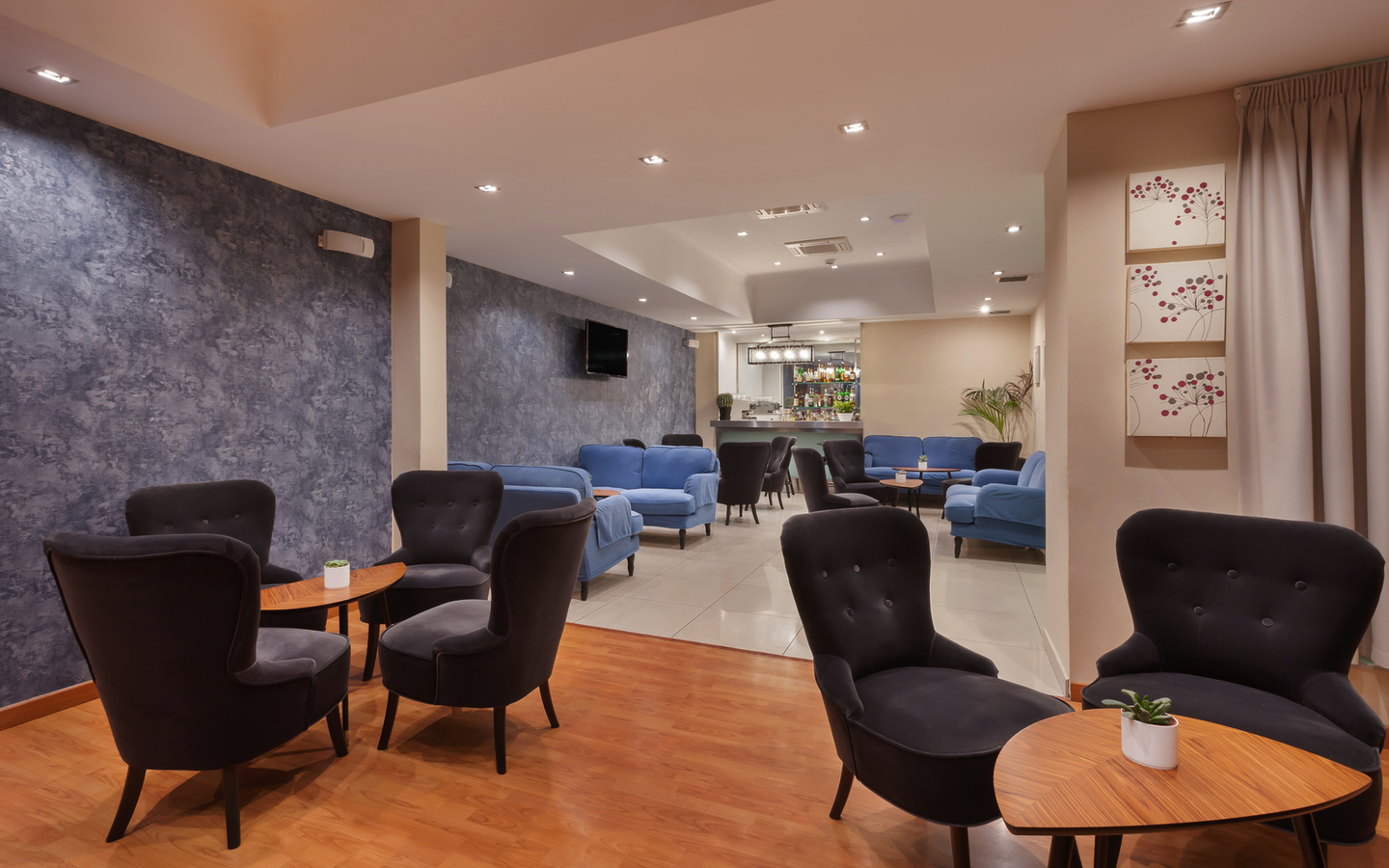 Hotel-Lounge mit Sesseln, Tischen und moderner Beleuchtung