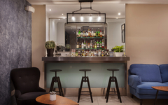 Hotelbar mit Barhockern, Tischen und Getränkeregal im Hintergrund