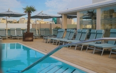 Poolbereich mit Liegestühlen und Sonnenschirmen am Hotel in Malta