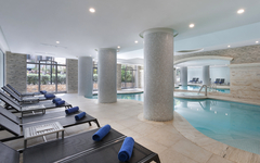 Innenansicht eines modernen Hotel-Spas mit Pool und Liegen.