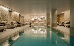 Luxuriöses Hallenbad im Hotel Hyatt Centric Malta mit eleganter Beleuchtung und Liegen.