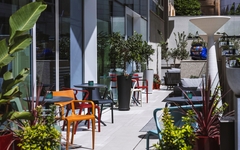 Außenbereich eines Hotels mit Pflanzen und bunten Sitzmöbeln