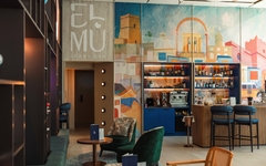 Moderne Hotellobby mit buntem Wandbild und stilvollen Sitzmöbeln.