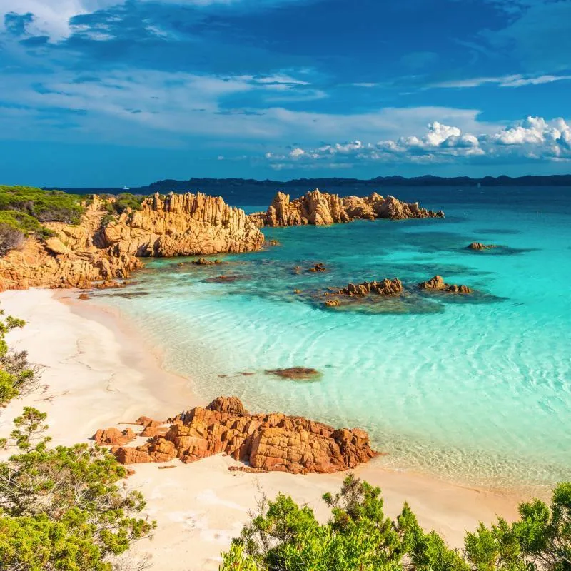 Küste des Maddalena-Archipels auf Sardinien mit klarem blauem Wasser und Felsen.