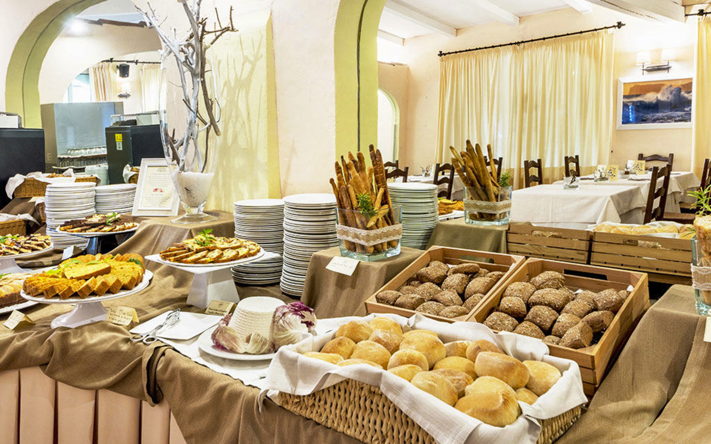 Frühstücksbuffet mit Brotauswahl und Gebäck in einem Hotelrestaurant.